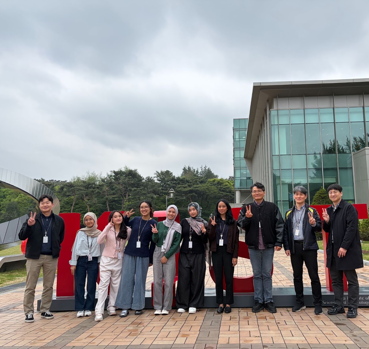 Group photo with visiting students from Rika's group in front of the KIST sign